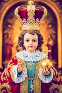 Divine Infant Jesus wearing a golden crown and red robe, blessing with His right hand — traditional Catholic image for the Christmas Novena.