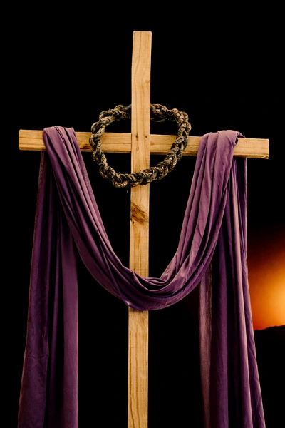 Wooden cross draped with purple cloth and crown of thorns during Lent